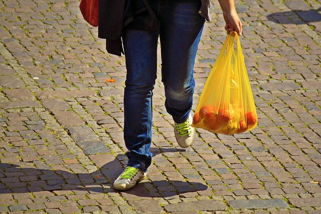 žena nese nákup v igelitové tašce